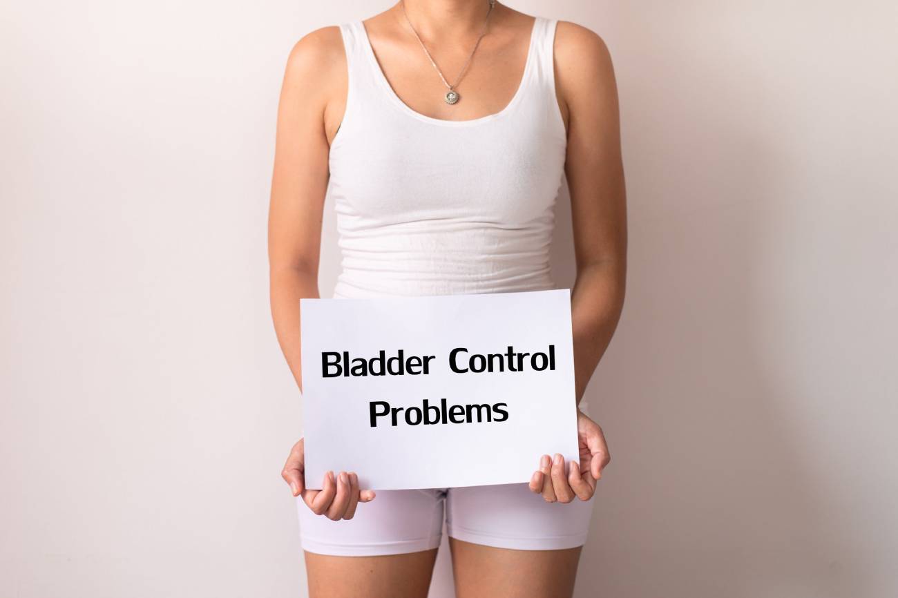 Woman holding a placard that reads bladder control problems.