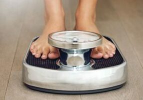 Weight-Loss A person checking weight on a weighing scale.